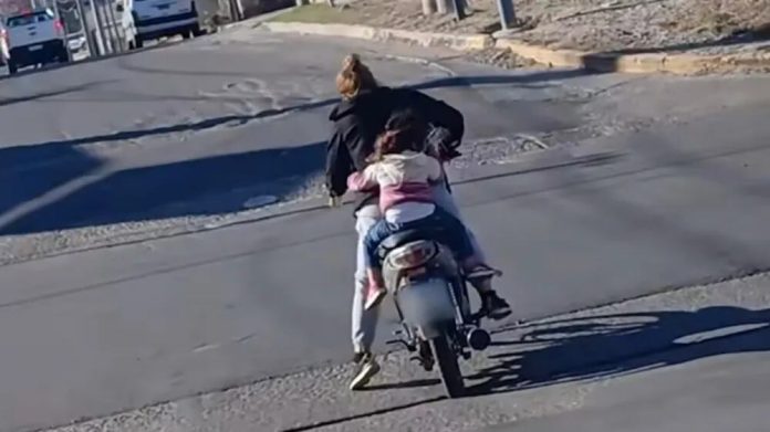 Insólito: una mujer manejaba una moto con una lata de cerveza en la mano y llevaba a una menor sin casco